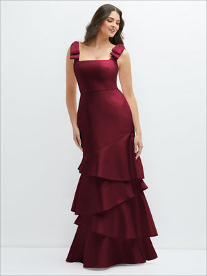Burgundy satin maxi dress with bow shoulder straps and asymmetrical tiered ruffle hem