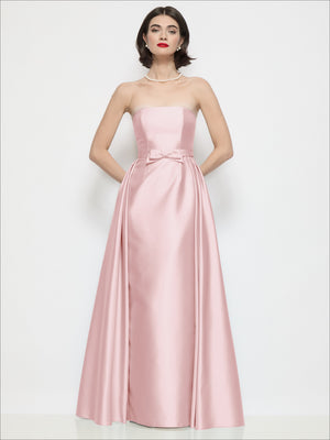 Blush pink strapless satin column dress with waist bow and draped overskirt