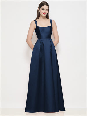 Navy satin maxi dress with square neckline, thin straps, fitted waist, pleated skirt