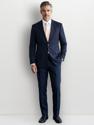 Blush pink modern tie worn with navy suit and white dress shirt